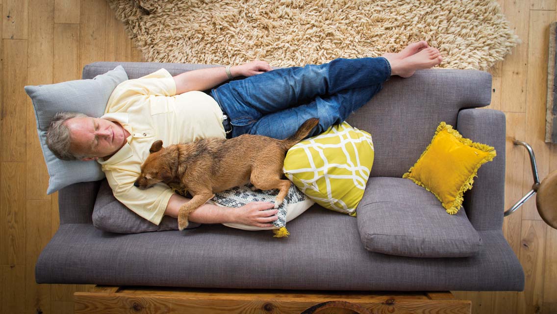a man naps with his dog