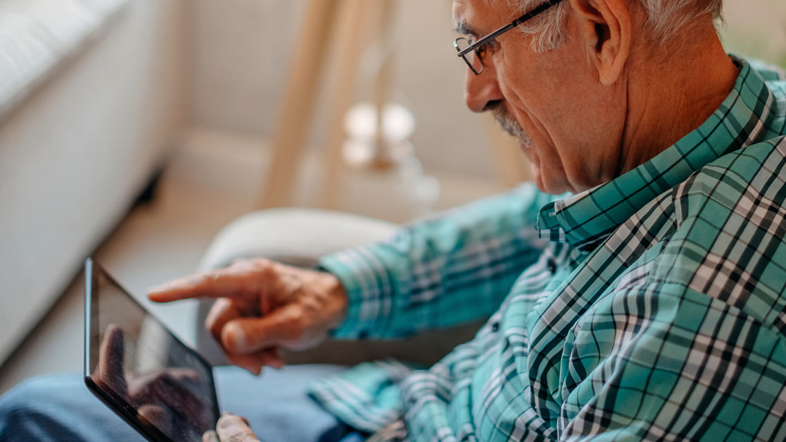 a senior man uses an iPad