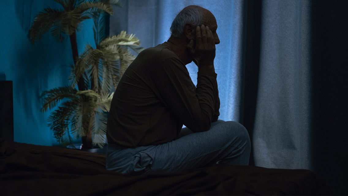 a man sits in a dark room