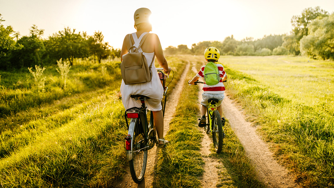 a mom and child bike on a country road
