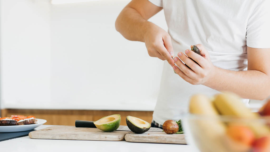 a man prepares an avocado to eat