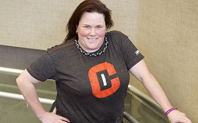 A woman stands and smiles