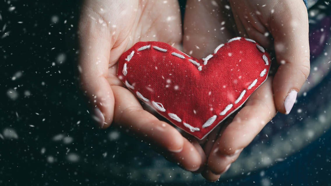 hands hold a homemade sewn heart