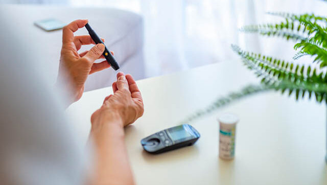 a person pricks a finger to take blood glucose level