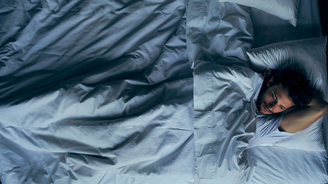 A man sleeping in a bed.