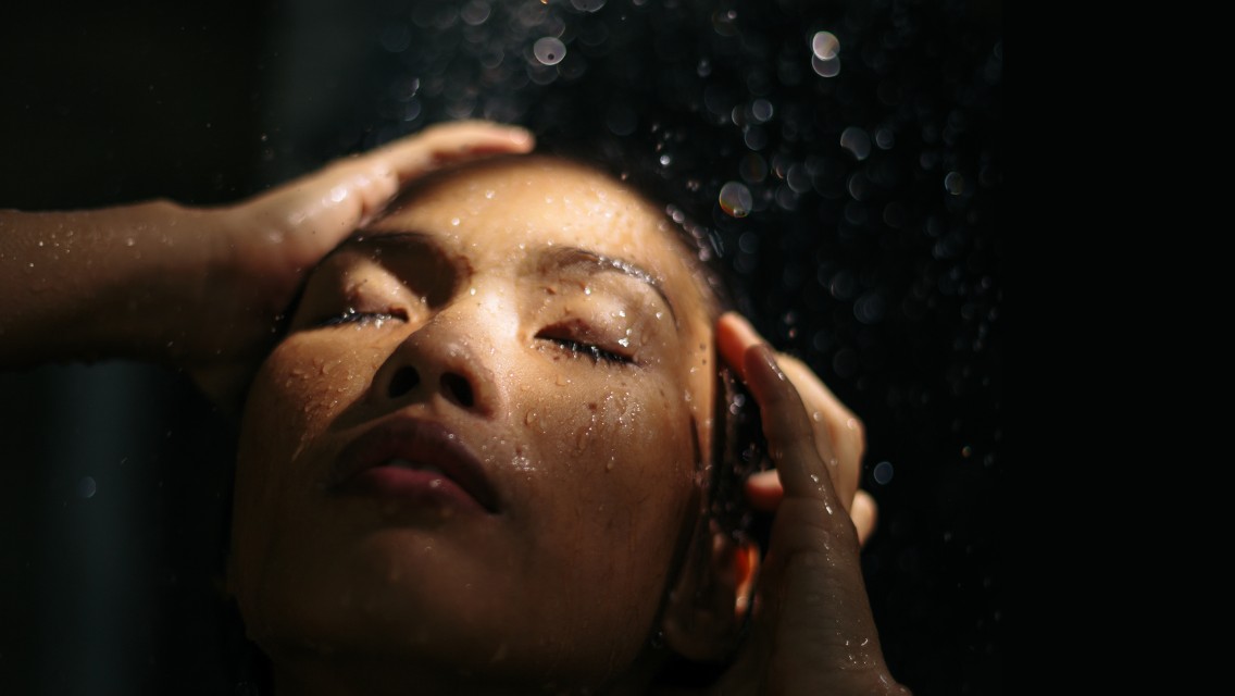 A woman washing her hair in the shower.
