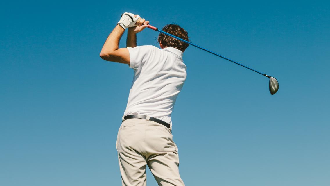 man swinging golf club
