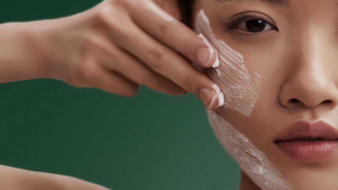 woman putting lotion on her face