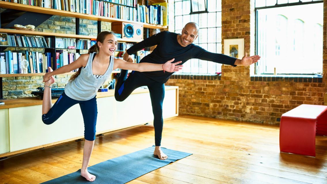 A father and daughter doing a workout at home together.