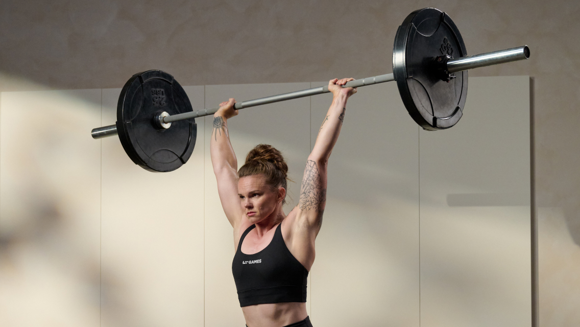 A woman doing an overhead barbell press