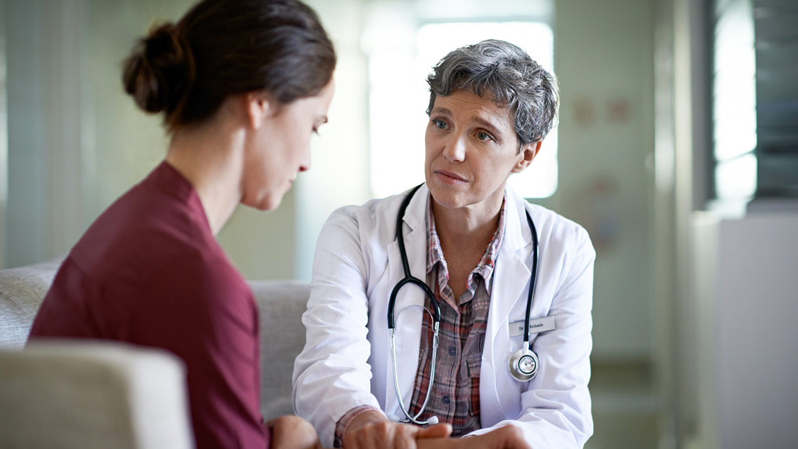 Doctor comforting a young woman