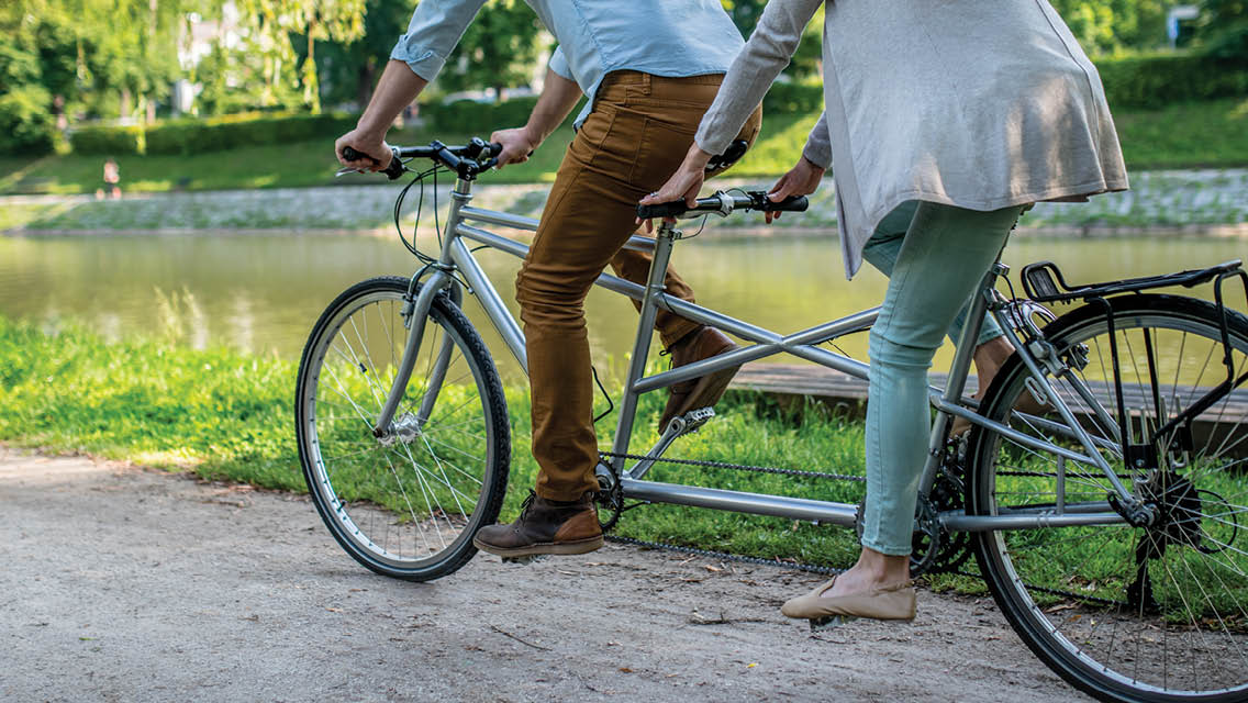 a couple rides a tandem bike