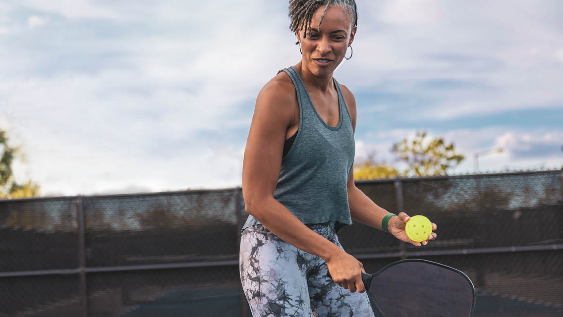 a woman plays pickleball