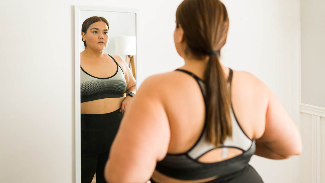 a woman looks at herself in a mirror