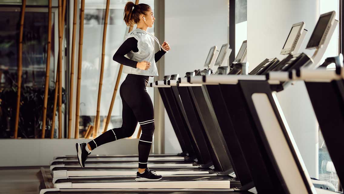 a woman walks on a treadmill