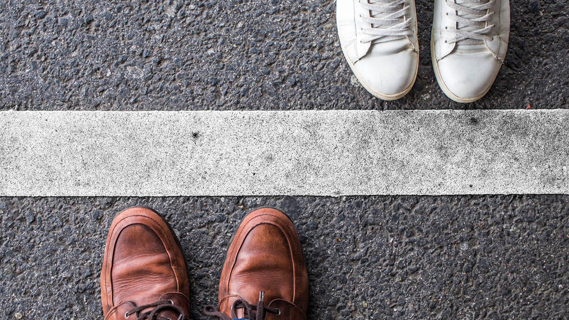 feet lined up on opposite sides of a thick, white line