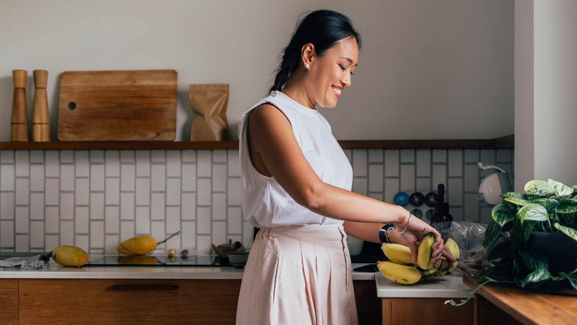 a woman prepares healthy food in her kitchen