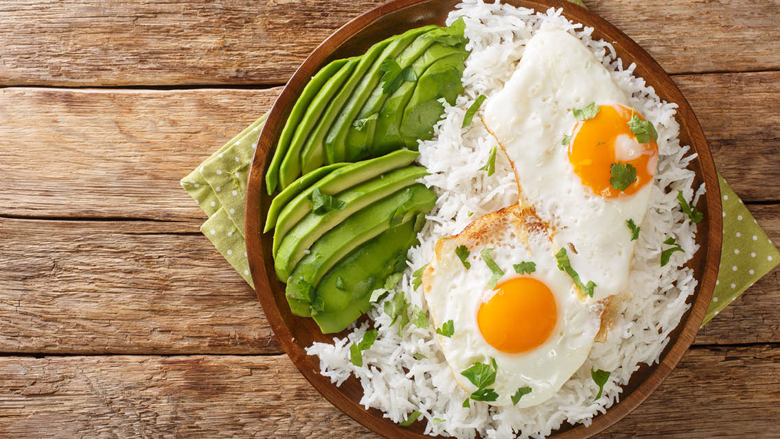a bowl with avocado, eggs, and white rice