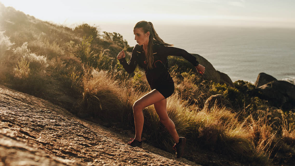 a woman sprints up a hill