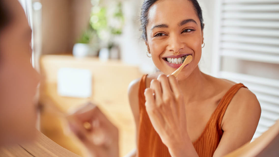 a woman brushes her teeth