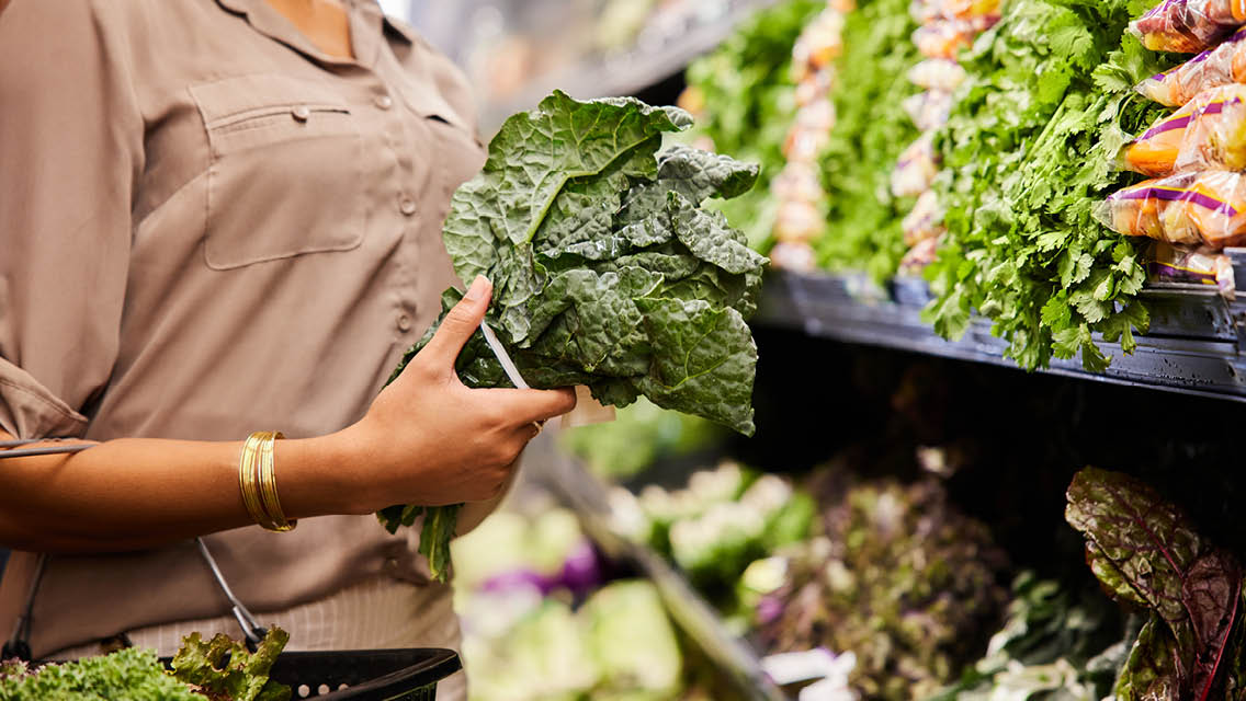 a person selects a bunch of kale