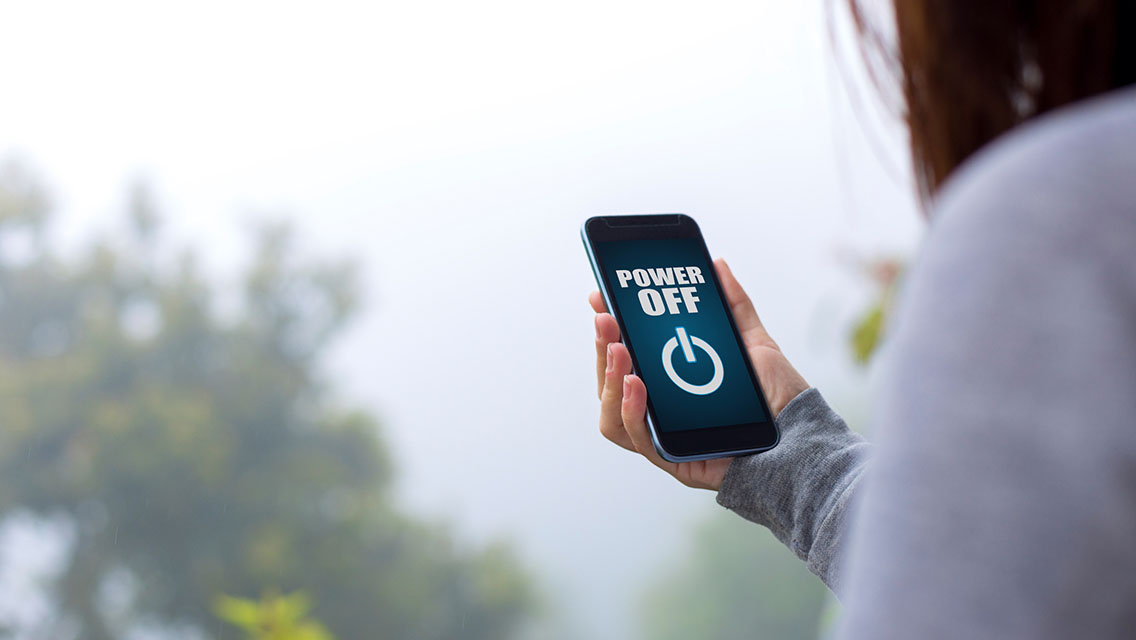A person shutting down her cellphone