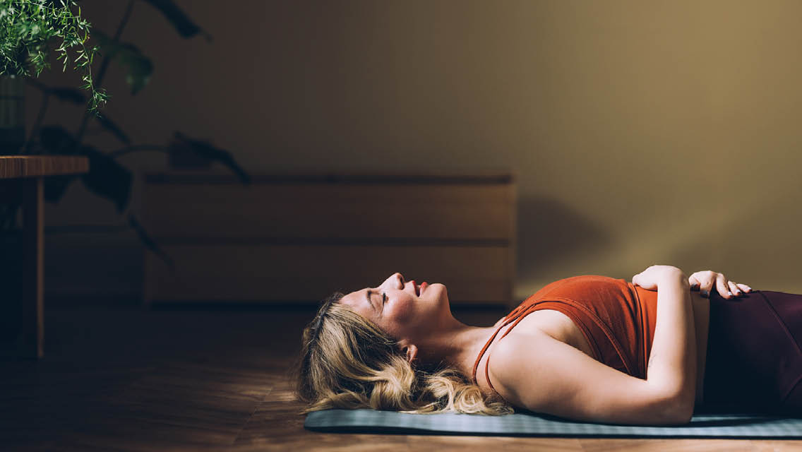 a woman lays in savasana