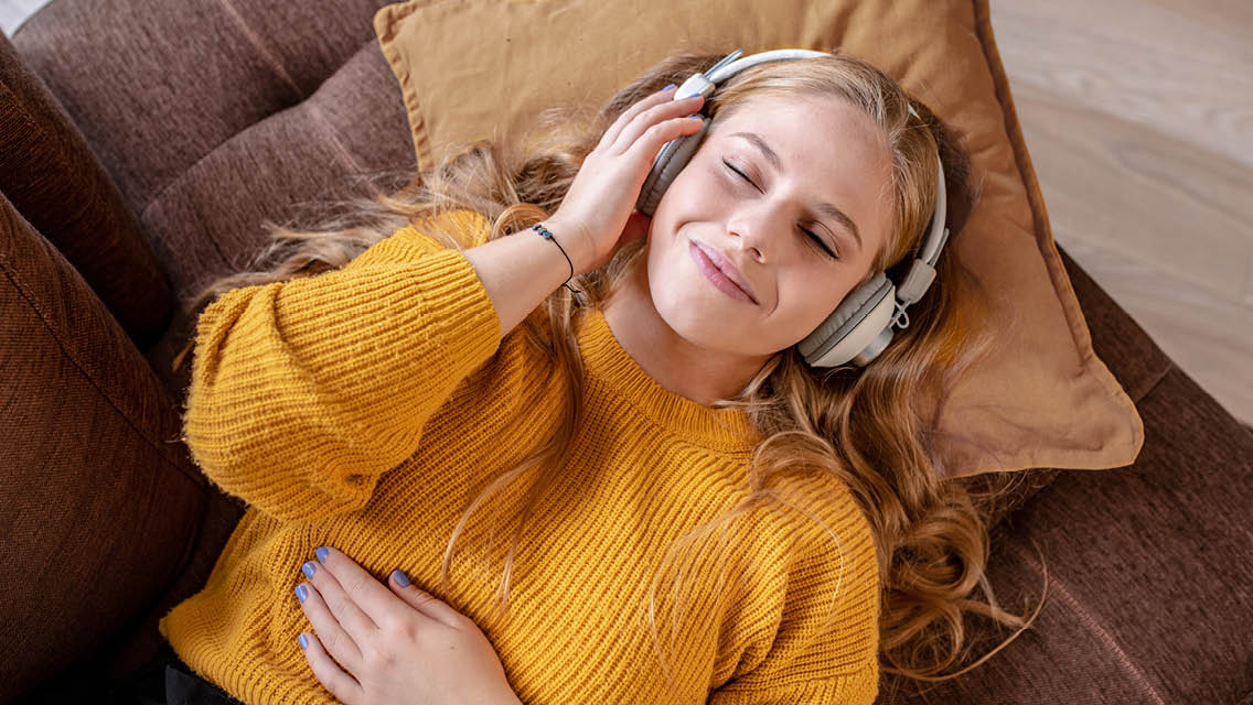 a young woman smiles with headphones on