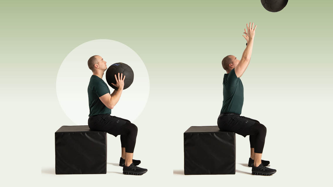 a man performs a seated wall ball