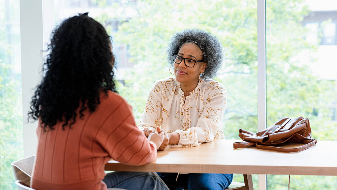 people hold hands across a table while talking