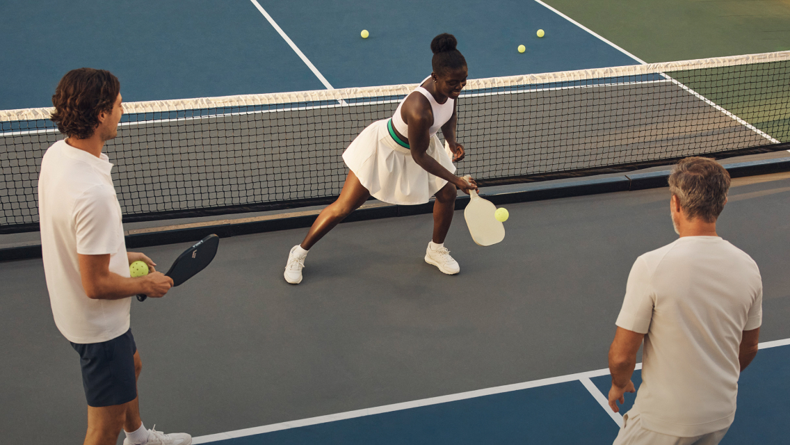 three people playing pickleball