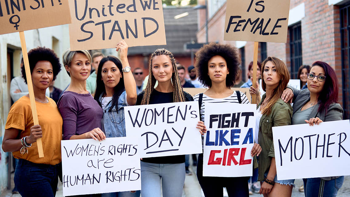 Several women are peacefully protesting with signs.