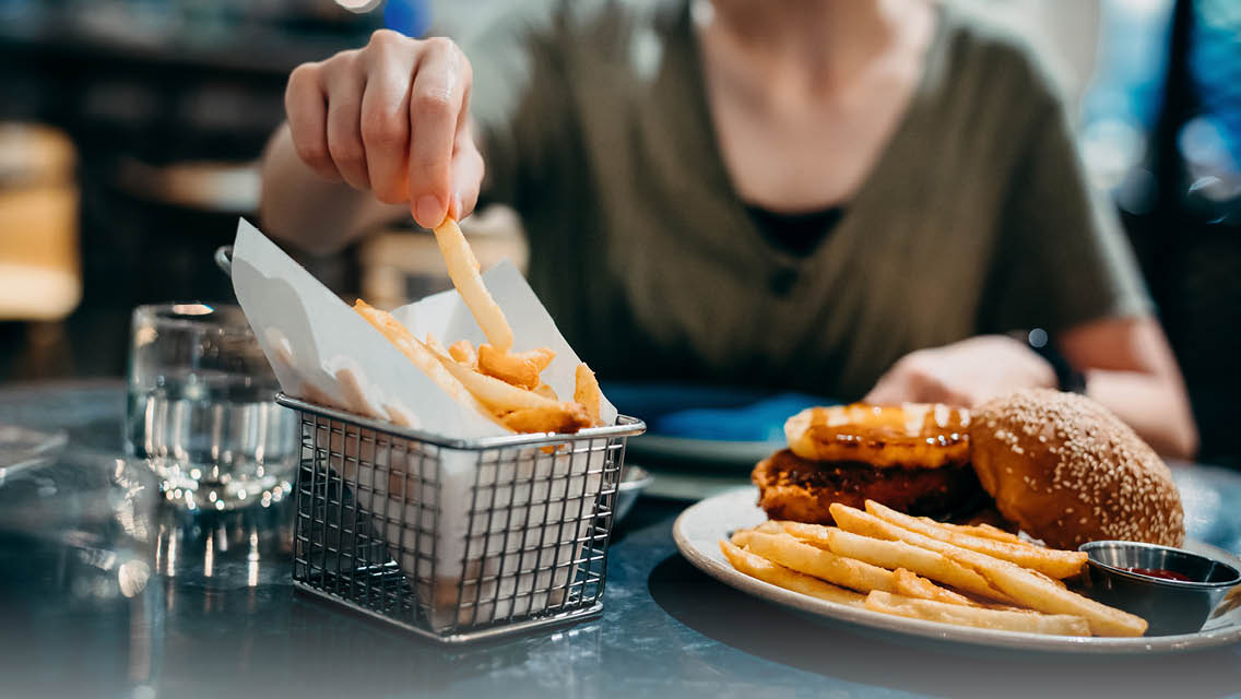 a person eating fries and a burger