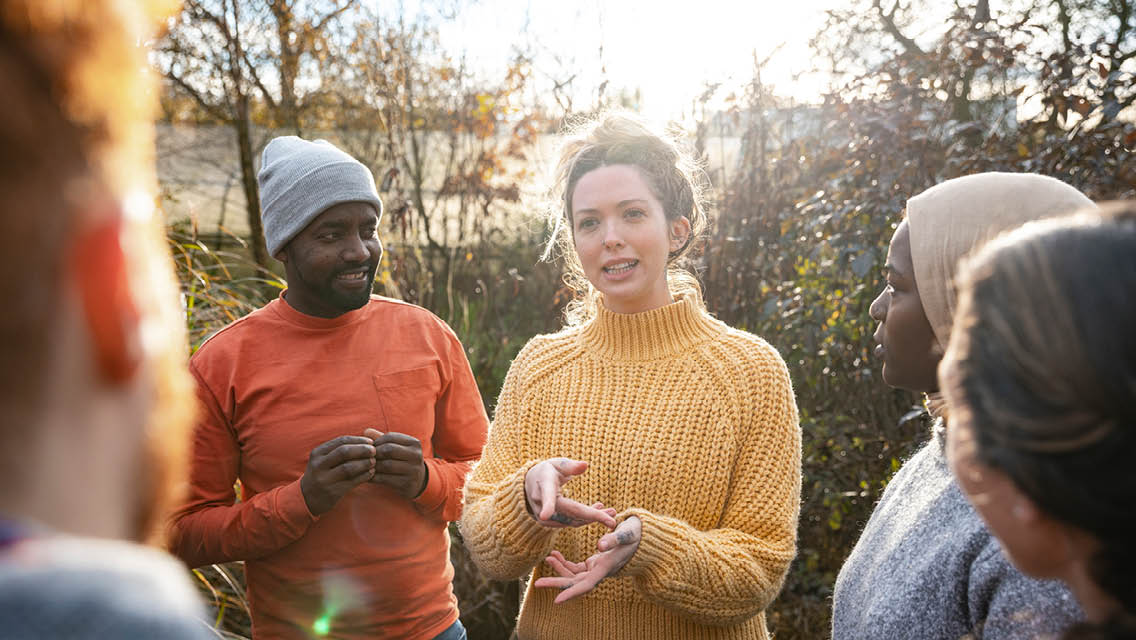 a woman uses sign language while presenting to a group