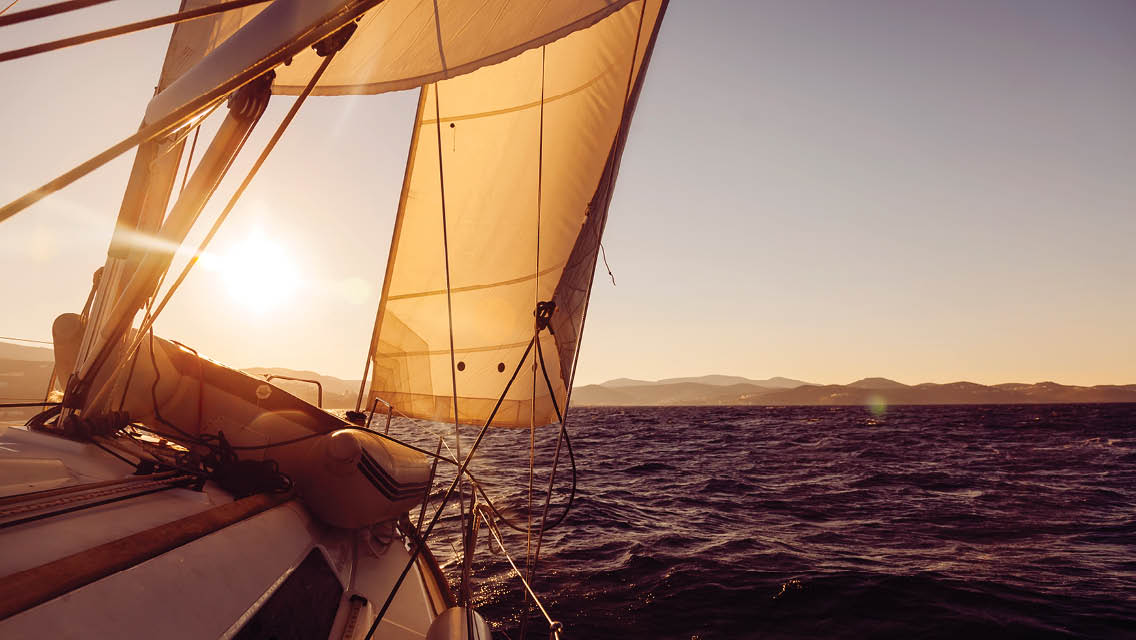 a sail boat at sunset