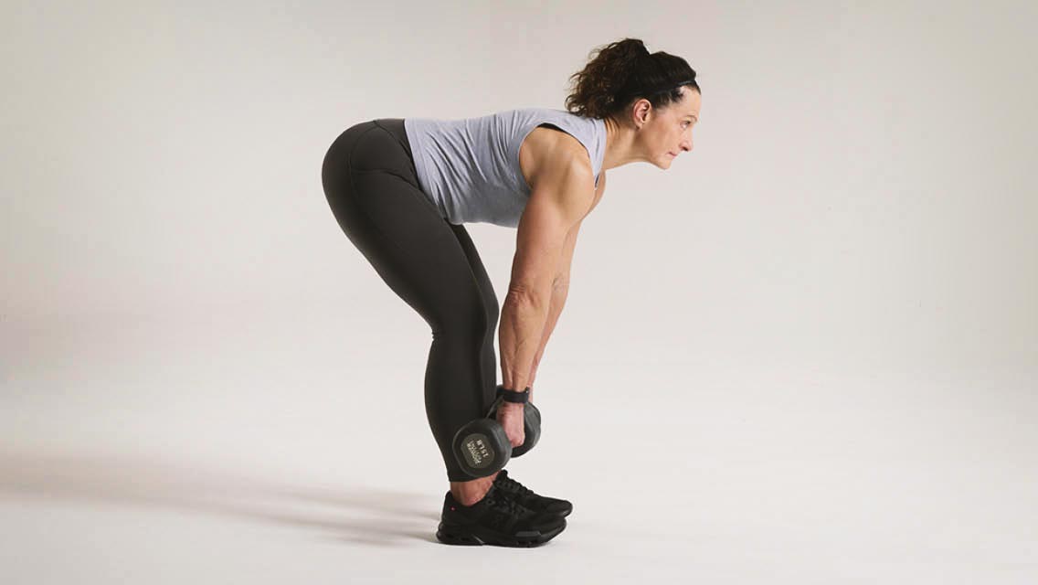a woman performs a dead lift