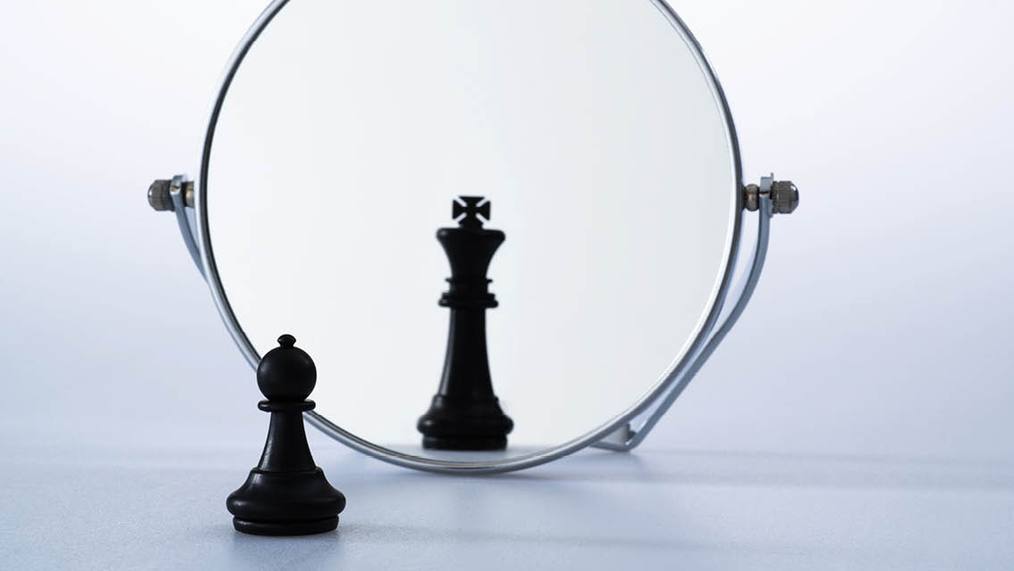 a chess pawns looks through a mirror and sees a king