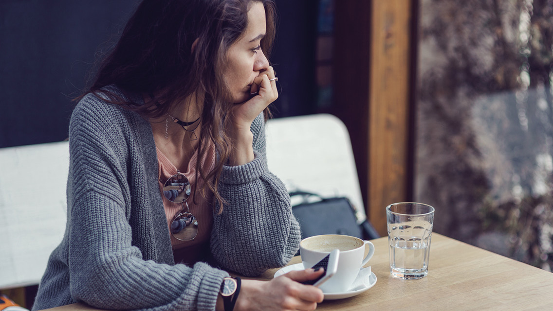 a woman sits with a pensive expression